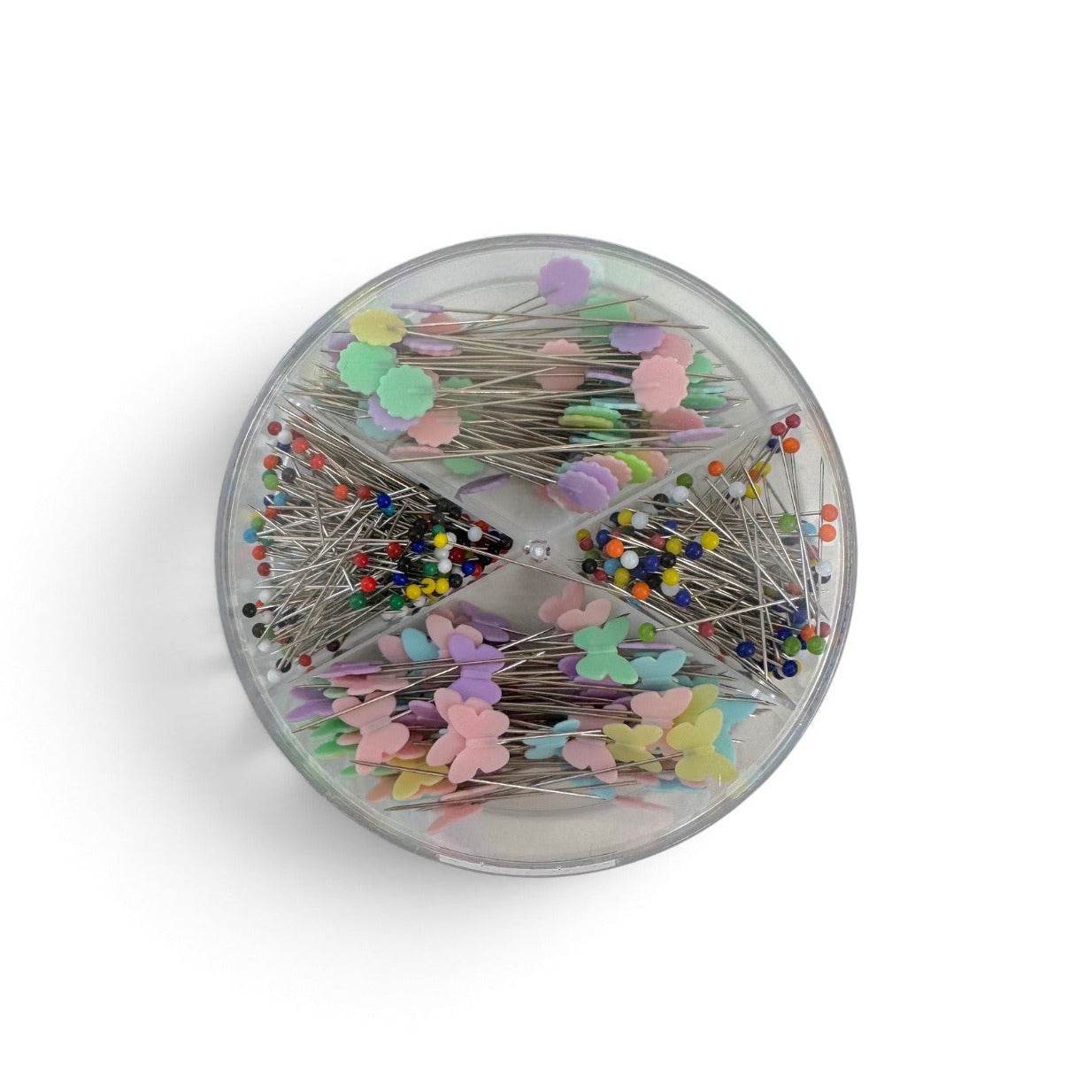 A round clear plastic container filled with decorative sewing pins featuring colorful pastel and bright tips, shown on a clean white background.